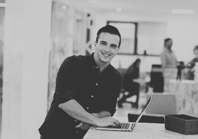 Man smiling for the camera in a shared office environment