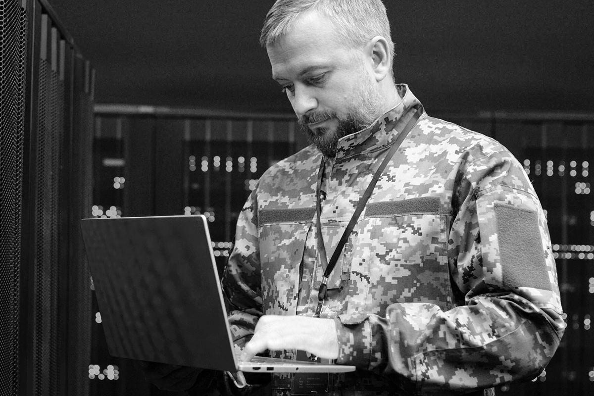 Military personnel working on laptop