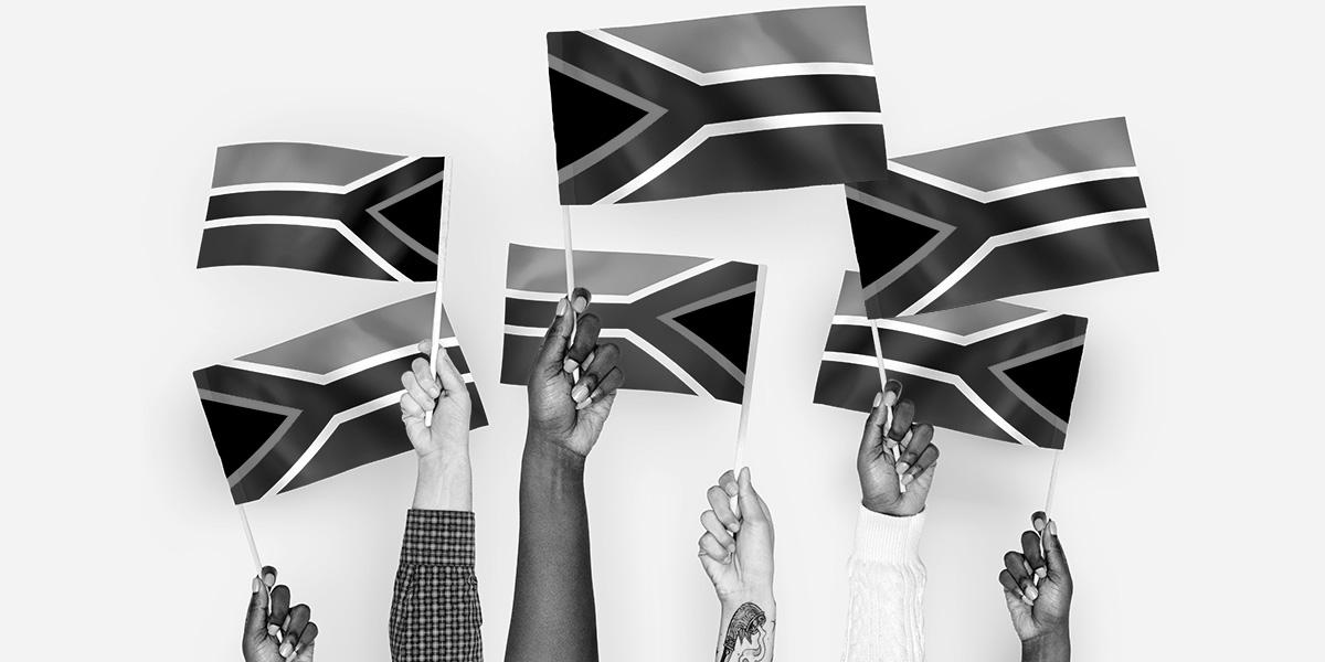 Hands holding up South African flags