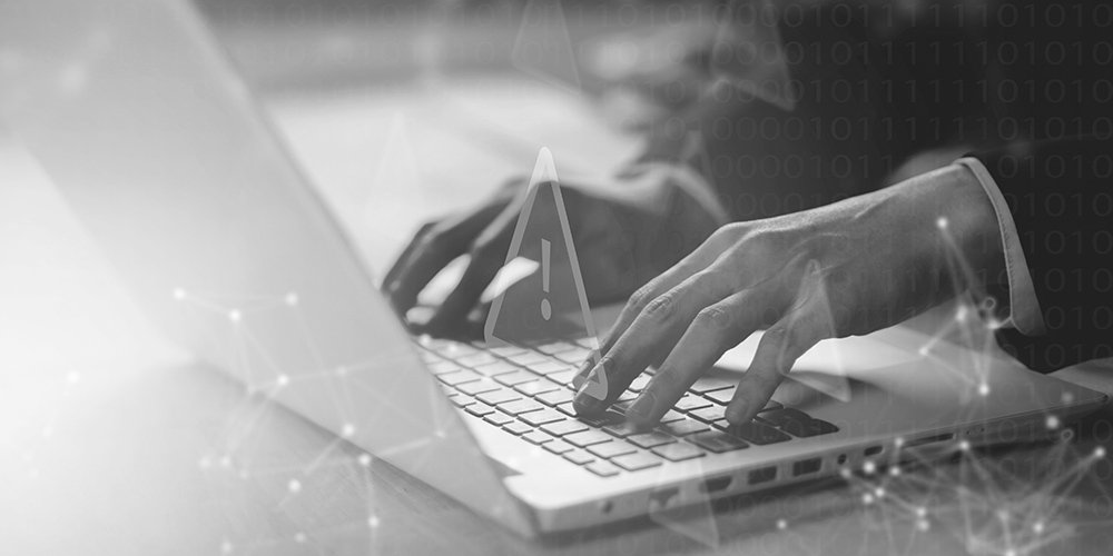 Hands typing on a laptop for threat engagement and disruption