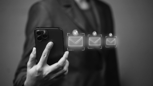 woman with a phone and three email envelopes